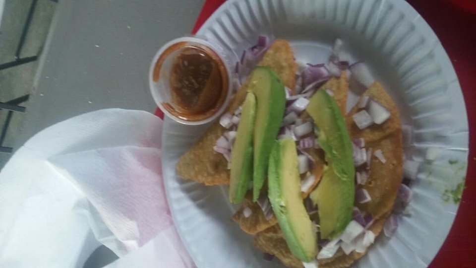 Spanish-language menu listing tacos, tostadas, and mariscos.