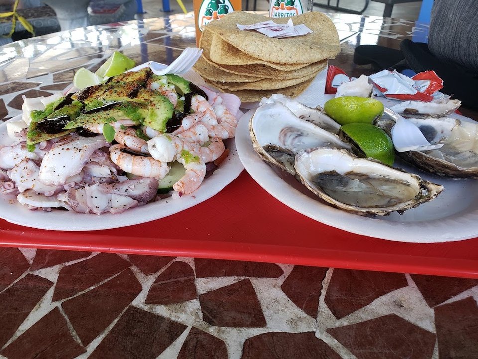 Spanish-language menu listing tacos, tostadas, and mariscos.